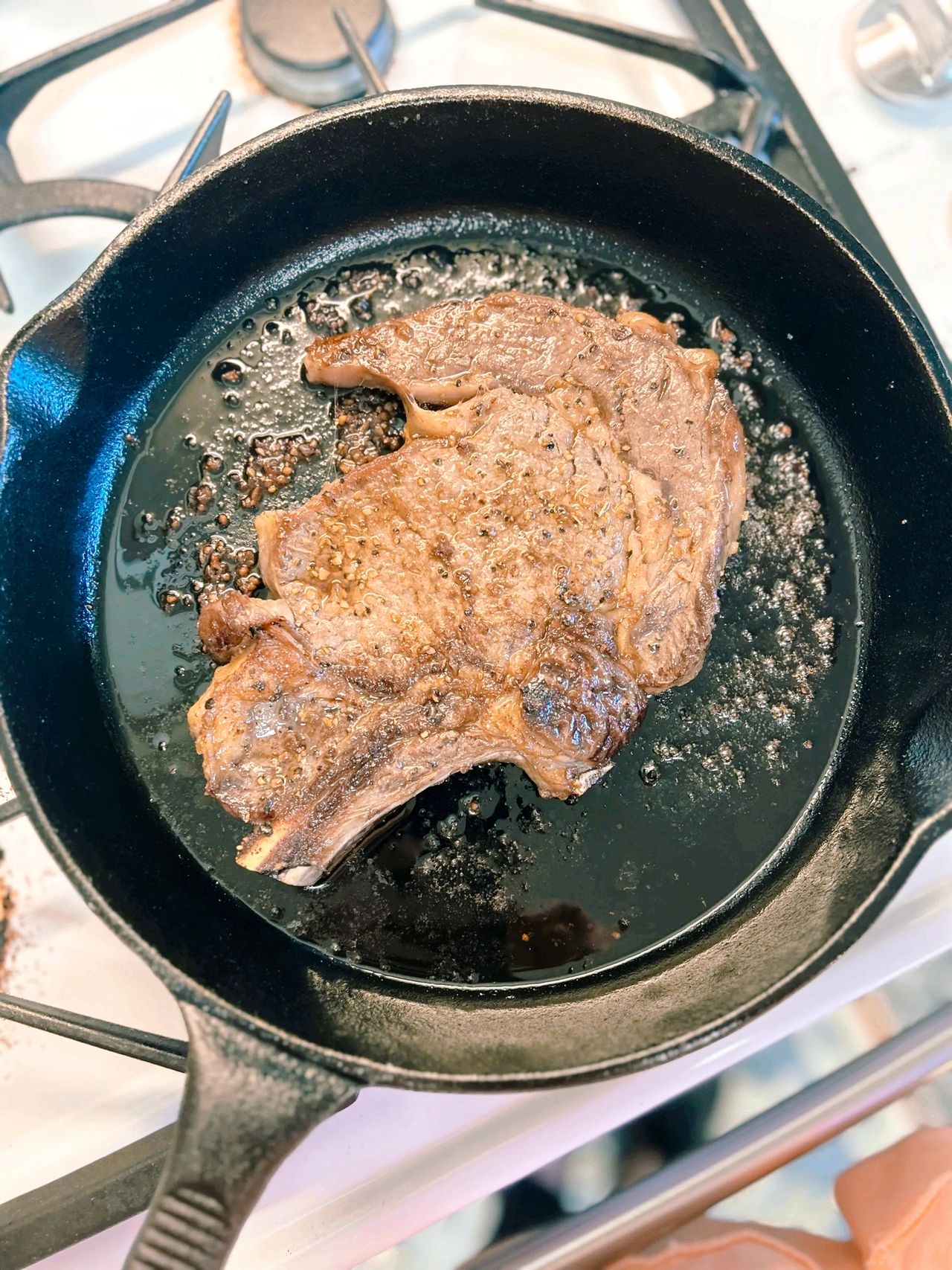 Cast-iron skillet with large steak in it.