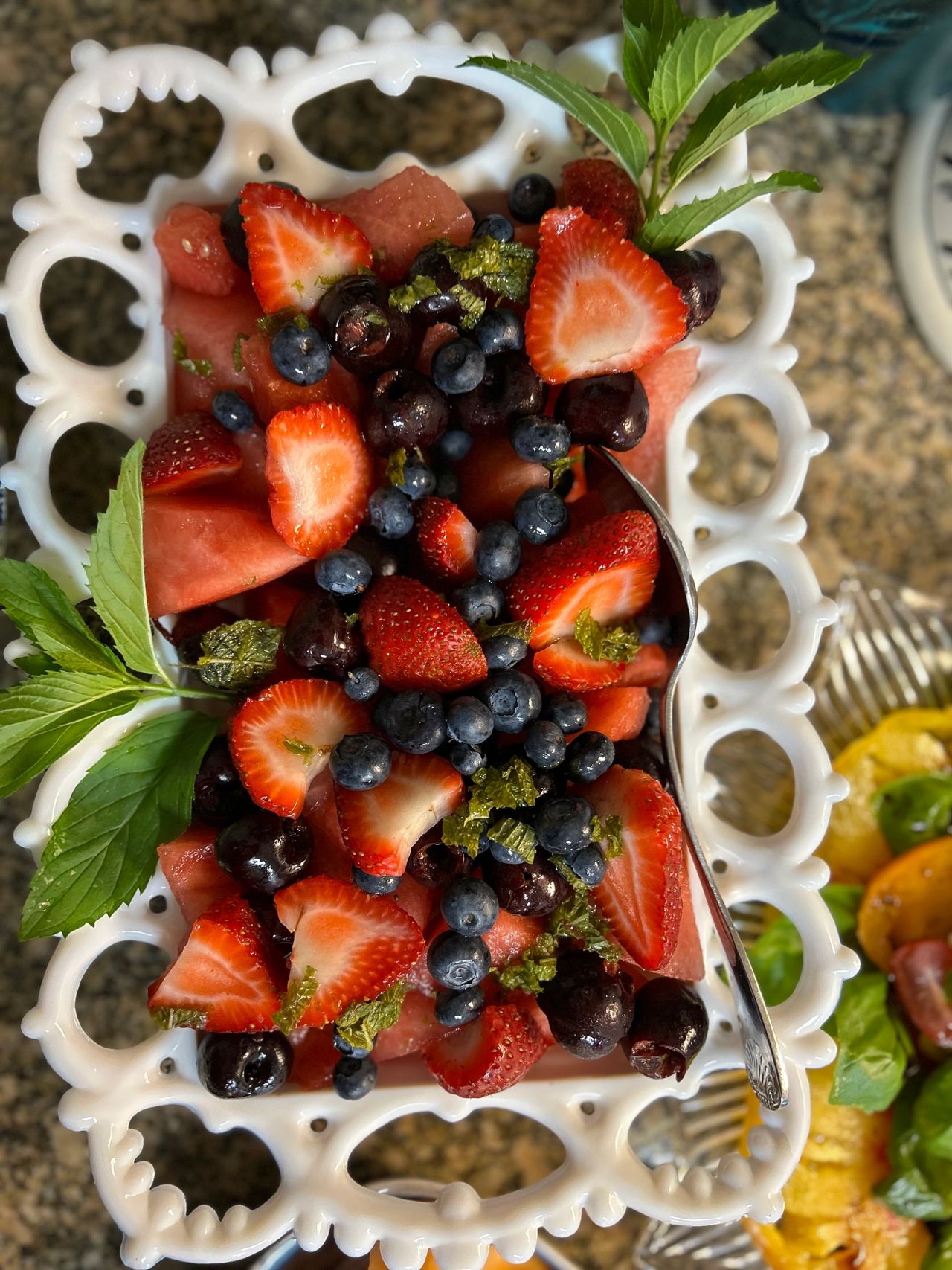 Watermelon, strawberries, blueberries in a white bowl