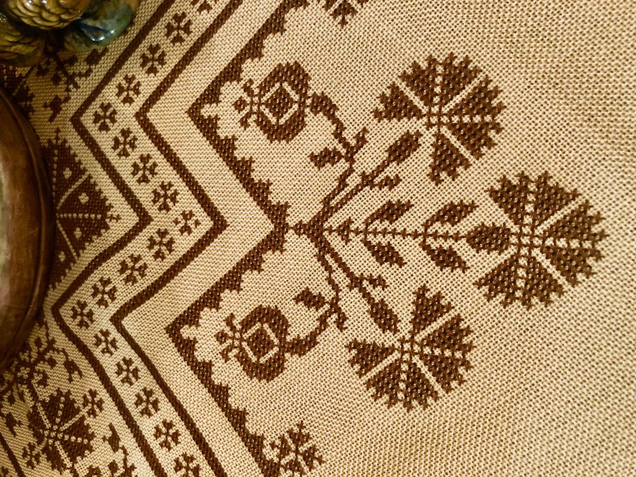 A brown cross-stitched tablecloth