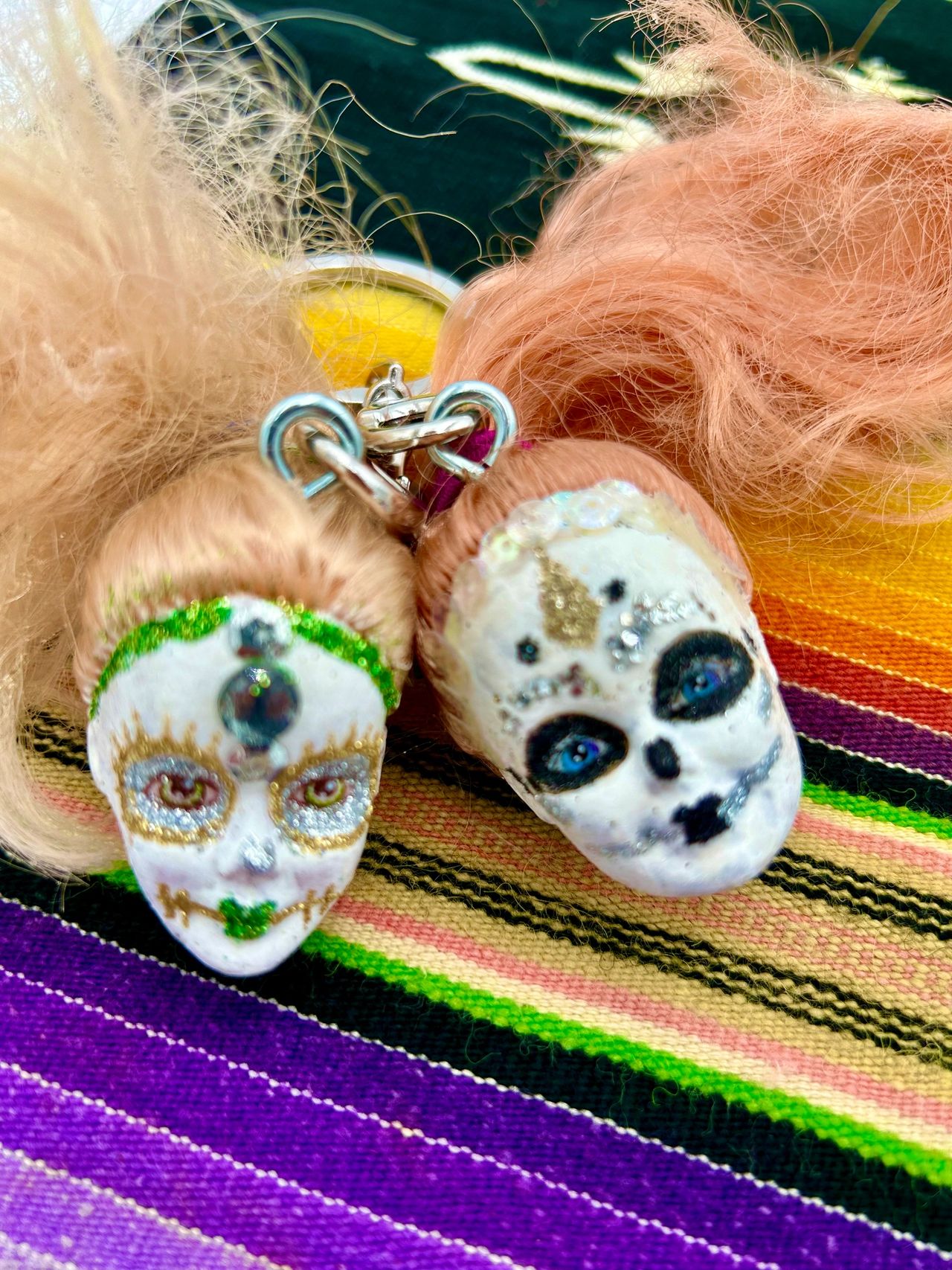 Two decorated Barbie heads on Mexican blanket