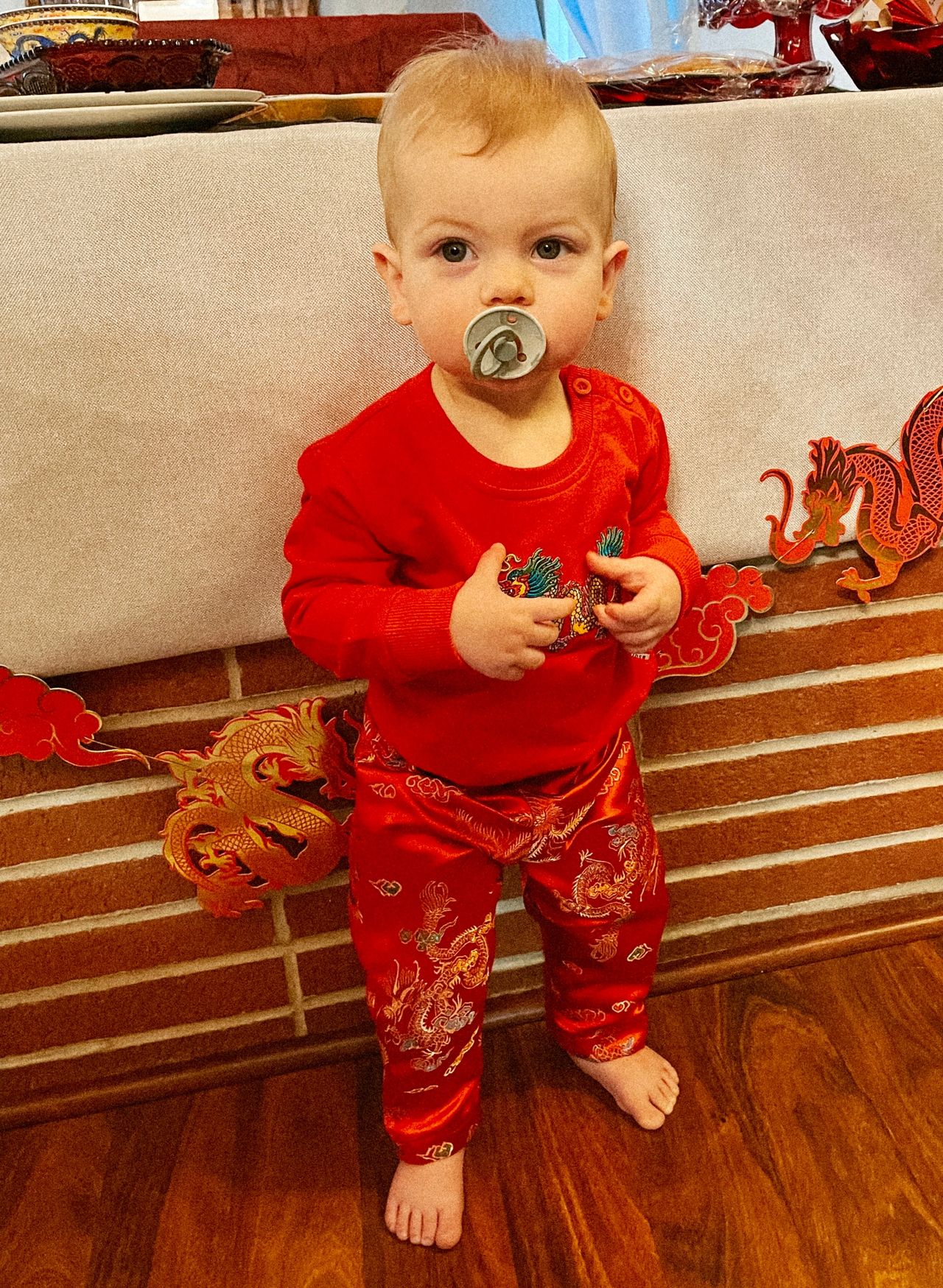 Little boy in red dragon sweatshirt and red silky Chinese pants.