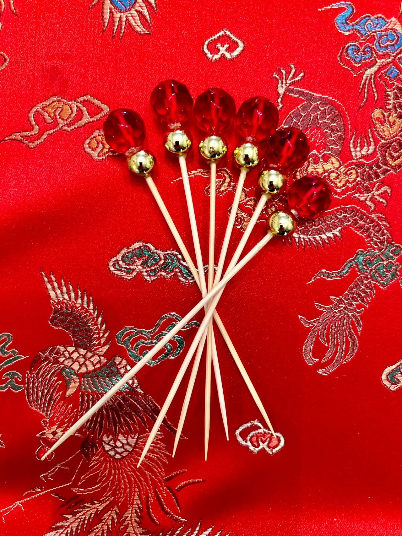 Red and gold cocktail picks on red background.