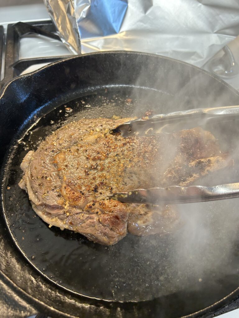 Testing the steak to see if it's ready.