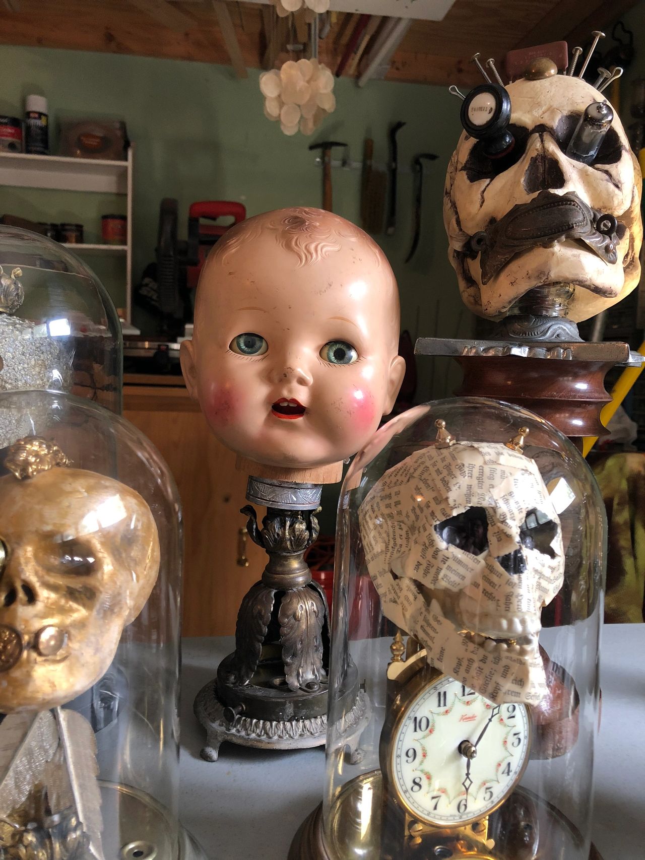 Creepy skulls and doll heads mounted on candlesticks.