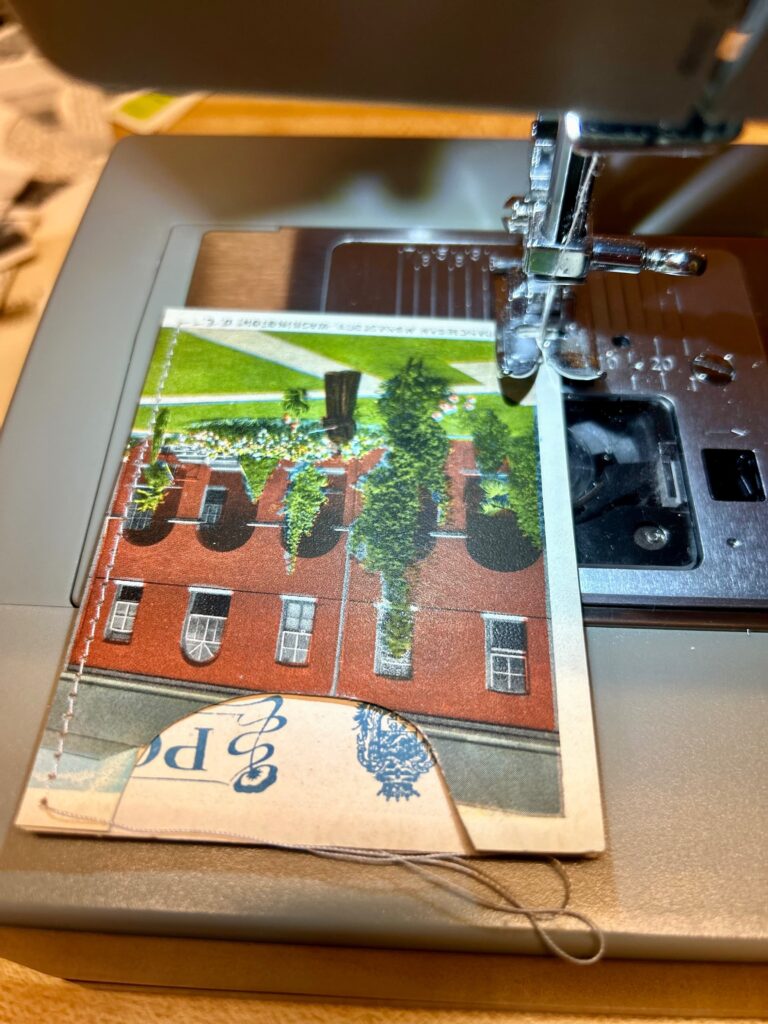 A postcard wallet being sewn